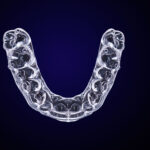 Aerial view of a clear aligner tray against a navy background